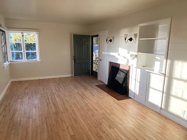 Front room with maple hardwood floors, built in cabinets and fireplace.