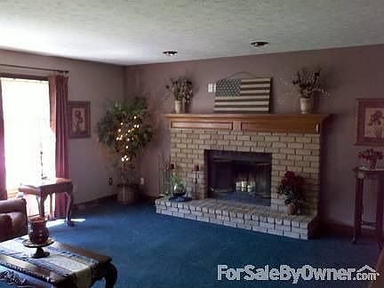 Spacious living room : Three large windows for natural light. Wood burning fireplace for cozy nights