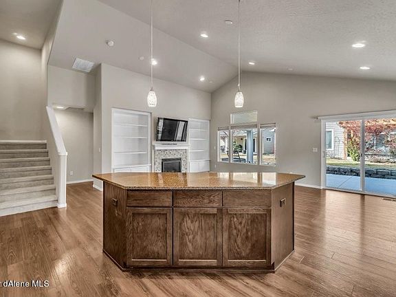Kitchen looking out to the great room. Primary bedroom is back behind the bookshelf