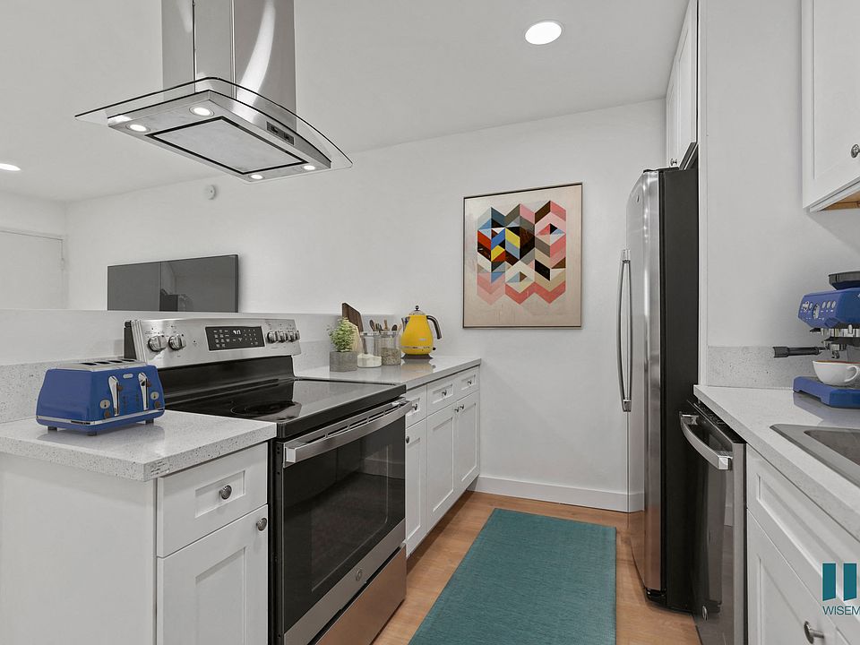 Open-Concept Kitchen with Stainless -Steel Refrigerator, Dishwasher, Stove, and Microwave