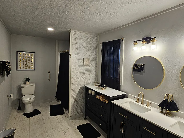 Spa-inspired bathroom with dual vanity, modern fixtures, updated lighting, and designer finishes