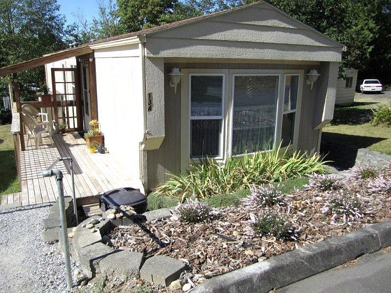As you drive through the park you will come upon this jewel sitting in a very sunny location. You can see it's surrounded by beds of Heather , Iris and Day Lillies. The gravel pathway leads from the parking to the deck and around the home to the back door. The home is very easy to maintain and affords a very comfortable lifestyle.