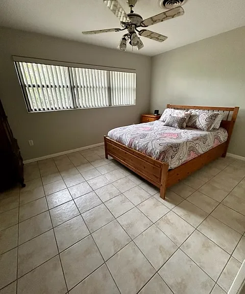 Large bedroom with high windows for privacy and great view of fenced in back yard.