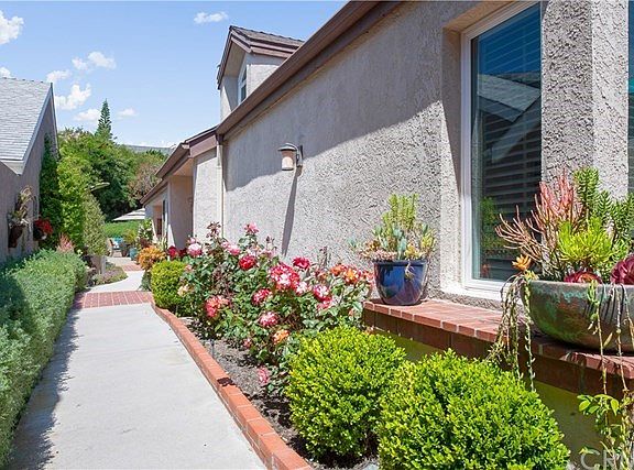 Walkway enhanced by blooming roses, lovely gardenscape.