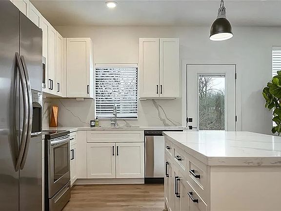 Modern kitchen featuring quartz-style countertops, stainless steel appliances, custom cabinetry, and open-concept design.

Photos are representative and finishes or layouts may vary slightly by unit.