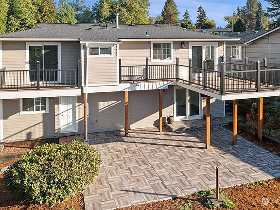 Back of home. Top level features two walk out decks. Beautiful pavers from lower level.>