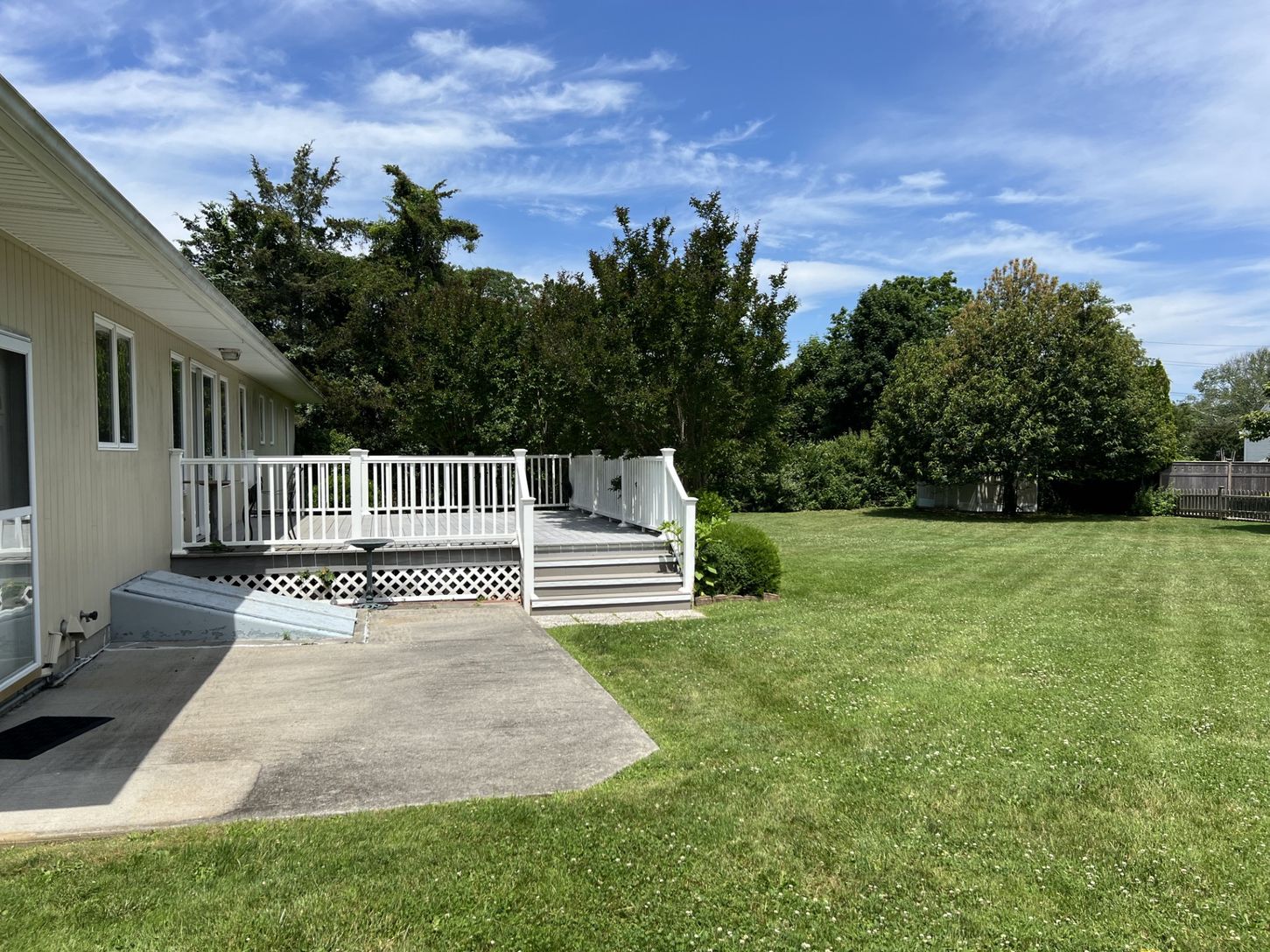 The deck and patio overlook a large backyard,