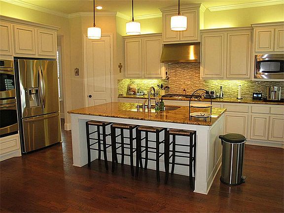 Gourmet kitchen also offers a huge serving bar with pendant lighting & stainless appliances!