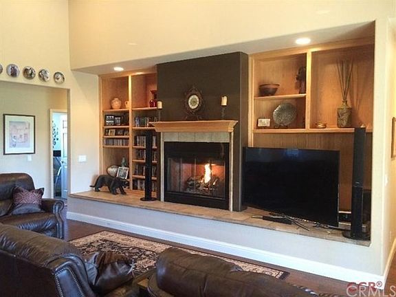 The great room is focused on this lovely fireplace and custom bookshelves