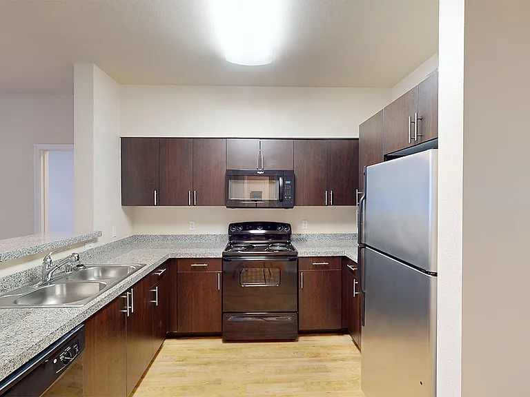 Apartment kitchen with wood-style flooring.