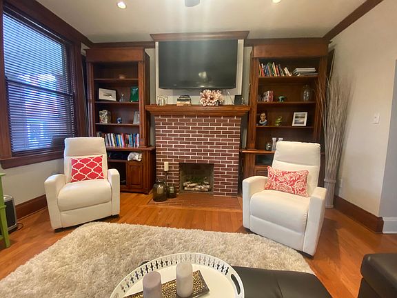 Living area with hard wood floors and built in bookcases.