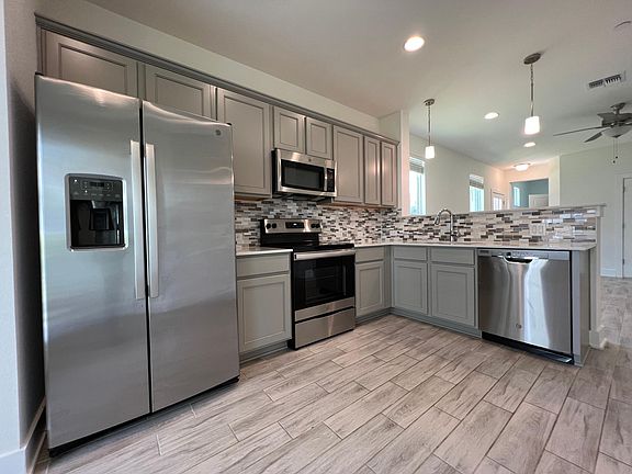 Full view of Kitchen. All stainless steel appliances, dual compartment sink with telescoping head.
