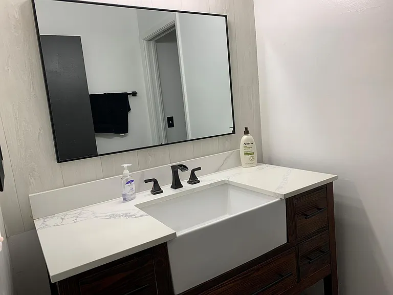 Vanity in the master bathroom inside the master bedroom suit. The drawers are full of supplies and the shelf underneath is full of towels.