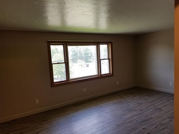 Living room featuring a picture window, all new ceiling and wall paint, and all new flooring.