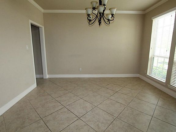 DINE IN STYLE IN THE FORMAL DINING ROOM WITH TILE FLOORS ON THE DIAGONAL AND CROWN MOLDING