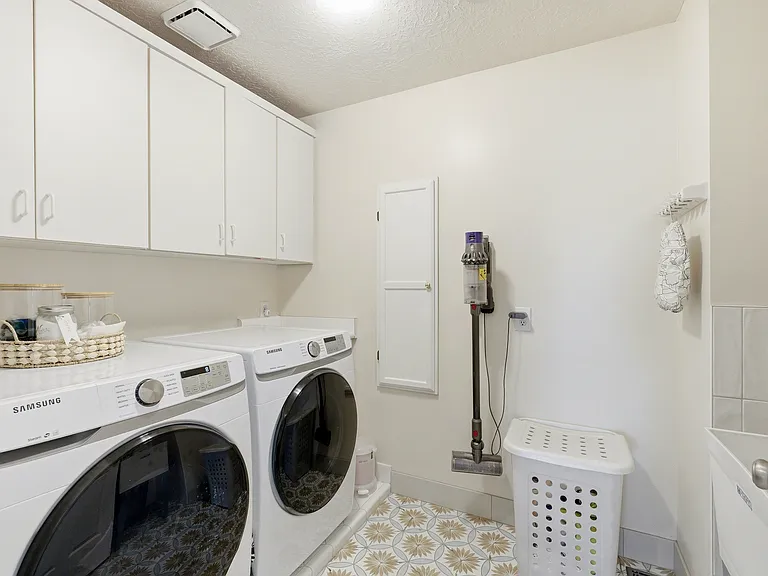 Dedicated laundry room with utility sink and included washer and dryer.