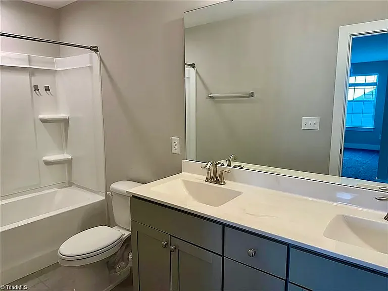 Upstairs guest bathroom with double vanity, bathtub and shower