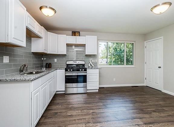Renovated kitchen with granite counter tops, stainless steel gas range, subway tile back splash, new
