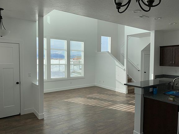 Living room with vaulted ceilings and south facing windows. Vinyl flooring throughout main floor.