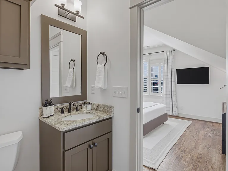 Shower/tub combo in bathroom 3, along with a hanging cabinet and vanity for storage.