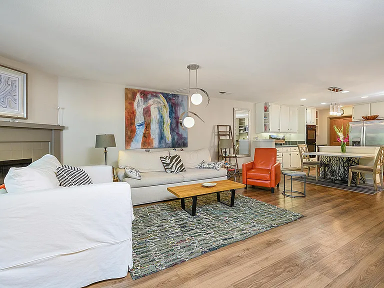 View of the living area opening up to the kitchen, with expansive French doors opening onto the gorgeous patio.