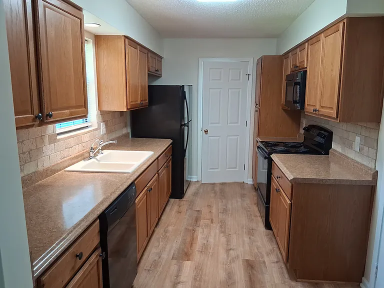 Wide galley kitchen with door to laundry room at rear