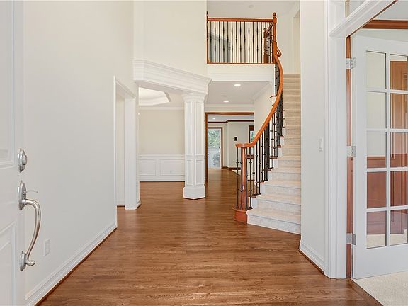 Soaring two-story foyer opens to sweeping staircase and formal/ informal spaces with stacks of gorgeous millwork and upscale finishes. 