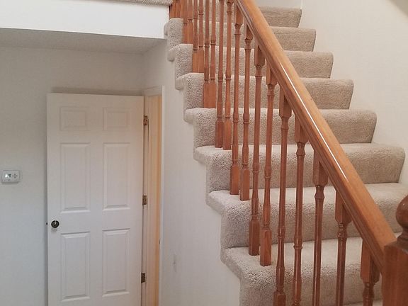 Stairs to top floor and door to basement stairs