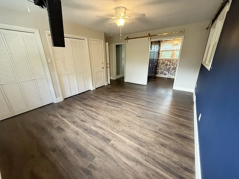 Master bedroom with WIC/office, and TONS of built-in storage space. Black thing is a ceiling mount for your TV.