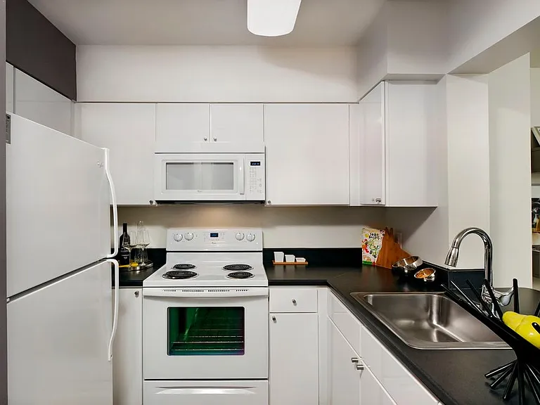 Classic Package kitchen with white cabinetry, white appliances and grey accent wall