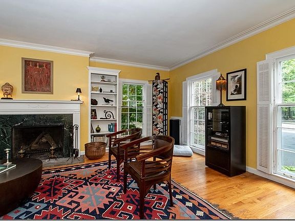 Hard wood flooring, crown moldings, a wood burning fireplace is anchored by two built in book cases.