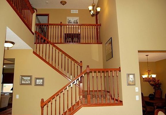 Dramatic center staircase with maple banister and balconies.