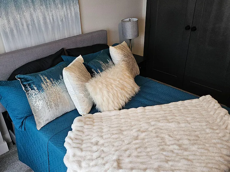 Furnished bedroom with a king-size bed, bedside lighting, and a spacious wardrobe for convenient everyday storage.