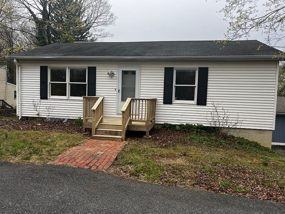 Front of home. Driveway with brick walkway and small entry deck.