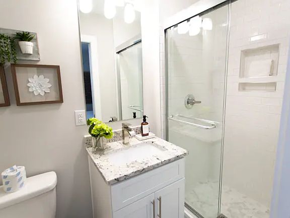 First-Floor Bathroom: Bright, modern bath with granite vanity and walk-in shower.