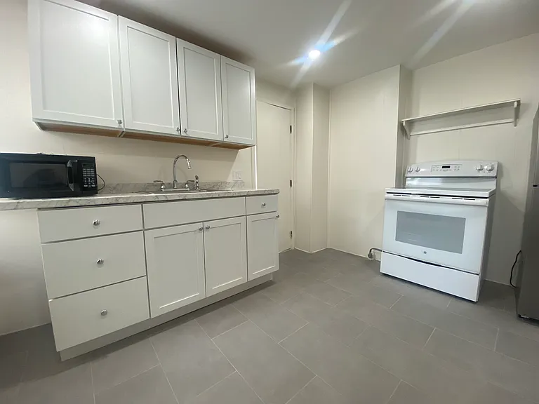 Kitchen has new cabinets and tiled flooring