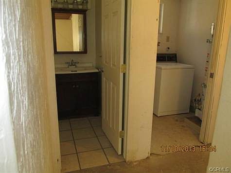 Hall bathroom has updated vanity and lights, tile floor; laundry