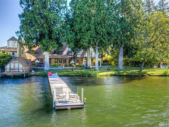 Classic 1927 English Tudor Revival is perfectly situated on .86 acre with 225 ft of lake front, boat house and new dock.