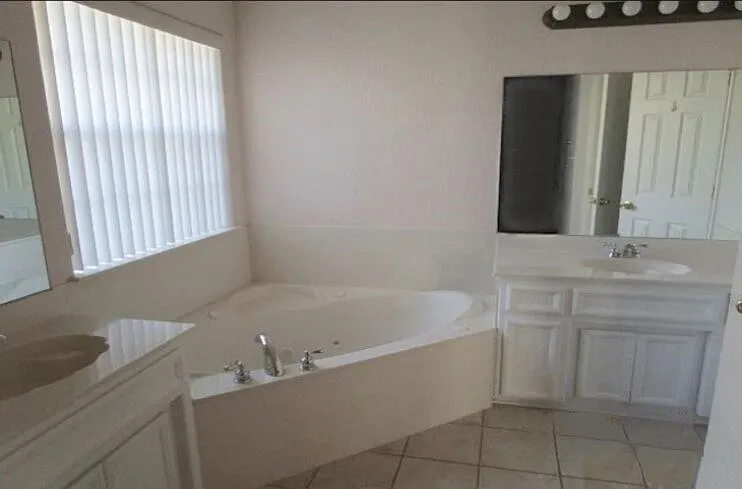 Master bathroom with relaxing jacuzzi tub, double sinks, and large walk-in closet.