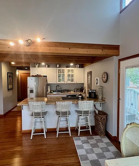 View from living room to kitchen, breakfast bar, and hallway leading to the bathroom, bedroom and hall closet.
