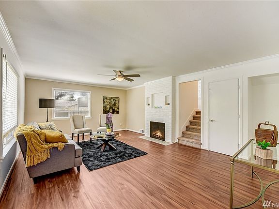 Spacious living room with ceiling fan and fireplace. 