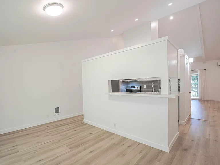 Corner view of the dining room and kitchen pass through that doubles as eat-at- bar top