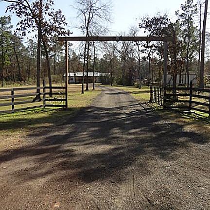 Front entrance of the 2.99-acre property from Riley Rd. featuring a recent gravel driveway.