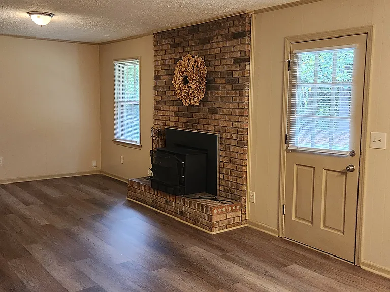 Family room with wood-burning stove and wall-mount TV bracket.