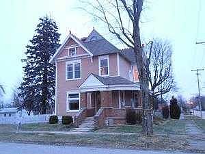 Front View Of Home With Wrap Porch and Fenced Yard
