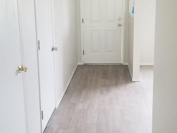 View of hallway looking toward front door with living room on right.