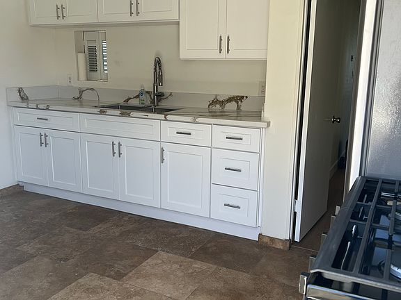 Remodeled Kitchen with brand new cabinets, countertops, sink, refrigerator, gas stove and ceiling fan