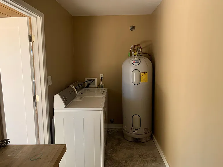 Washer and dryer included in outdoor laundry room.