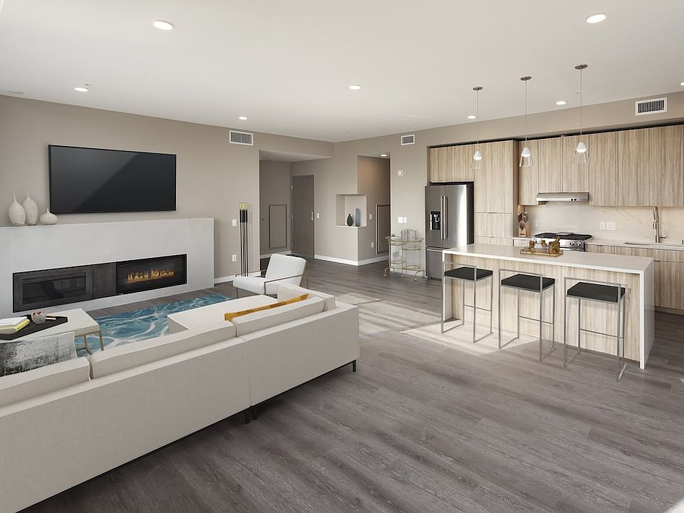 Signature Collection penthouse kitchen, dining area, and living room with fireplace and hard surface flooring.