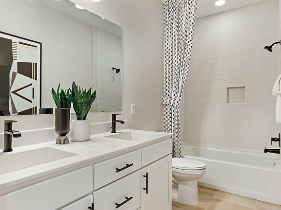 Secondary bathroom with white countertops, a double sink, and a shower tub combo.